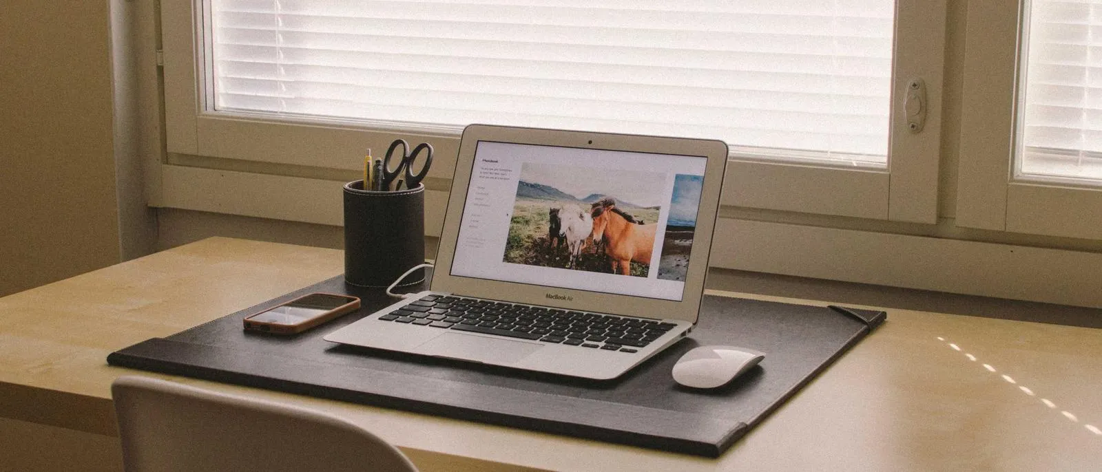 Laptop auf einem Schreibtisch am Fenster
